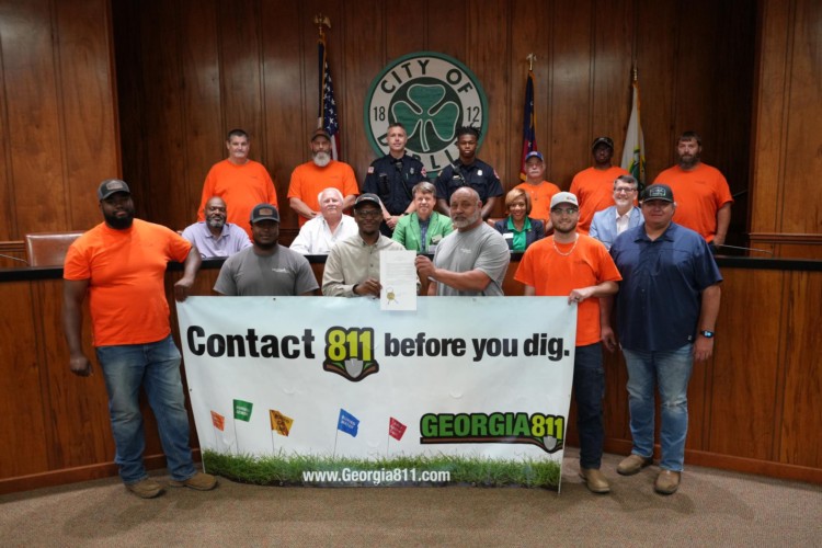 Mayor with Gas and Fire Departments holding the proclamations signed and a banner with 811 information.